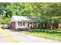 Inviting home with brick accents, well-kept landscaping, and a long driveway leading to the front entrance at 1115 Grovewood Dr, Charlotte, NC 28208