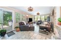 Bright sunroom with tiled floors, leather furniture, multiple windows, and pleasant outdoor views at 1115 Grovewood Dr, Charlotte, NC 28208