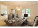 Elegant dining room featuring a wooden table set with fine china and a decorative chandelier at 12314 Chickasaw Dr, Huntersville, NC 28078