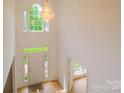 Bright and airy foyer with a striking chandelier, large windows, and light hardwood flooring at 12314 Chickasaw Dr, Huntersville, NC 28078
