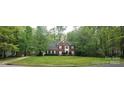 Charming two-story brick home with well-manicured lawn and lush greenery at 12314 Chickasaw Dr, Huntersville, NC 28078