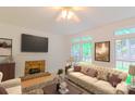 Bright living room with a brick fireplace, plush sofa, and large windows offering ample natural light at 12314 Chickasaw Dr, Huntersville, NC 28078