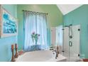 Luxurious bathroom with a soaking tub, glass-enclosed shower, and stylish fixtures at 1337 Braeburn Nw Rd, Concord, NC 28027