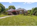 Beautiful brick home with mature landscaping and a well-manicured lawn on a sunny day at 1337 Braeburn Nw Rd, Concord, NC 28027