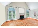 Bright living room featuring a fireplace, hardwood floors, and natural light from large windows at 1337 Braeburn Nw Rd, Concord, NC 28027