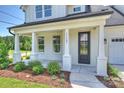 Inviting front porch with white columns and a view of the landscaped front yard at 13605 Tranquil Day Dr, Matthews, NC 28105