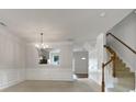 Spacious living room with elegant crown molding, staircase, and open archway to the dining area at 14056 Lyon Hill Ln, Huntersville, NC 28078