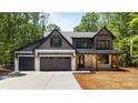 Stunning two-story home with a three car garage, modern farmhouse design, and covered front porch at 1408 Bloomsberry Ln, Waxhaw, NC 28173
