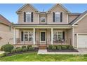 Inviting front porch with black metal railings and decorative columns offers curb appeal at 1455 Moss Creek Dr, Harrisburg, NC 28075