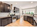 Modern kitchen featuring granite countertops, stainless steel appliances, and wooden floors at 1455 Moss Creek Dr, Harrisburg, NC 28075
