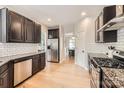 Well-lit kitchen showcasing stainless steel appliances, granite countertops, and light wood floors at 1455 Moss Creek Dr, Harrisburg, NC 28075