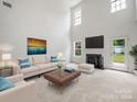 Bright living room with high ceilings, a cozy fireplace, and stylish neutral decor at 2020 White Cedar Ln, Waxhaw, NC 28173