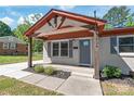 Well maintained front porch with gabled entry, brick siding, manicured garden bed, and stylish gray front door at 3932 Slagle Dr, Charlotte, NC 28215