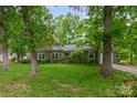 Inviting single-story home with green lawn, mature trees, and a charming front entrance at 408 Idlewood Dr, Kannapolis, NC 28083