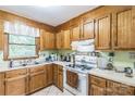 Traditional eat-in kitchen with wood cabinets, white appliances, and a tile floor at 4424 Huntington Dr, Gastonia, NC 28056