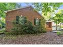 This brick house features a lush, landscaped foundation and classic black shutters at 4424 Huntington Dr, Gastonia, NC 28056