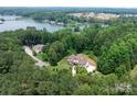 Expansive aerial view of lakefront home with lush green surroundings, nestled in a serene and secluded setting at 4616 Gold Finch Dr, Denver, NC 28037