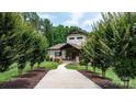 Stunning home exterior showcasing a long driveway lined with trees, leading to a beautifully landscaped front yard at 4616 Gold Finch Dr, Denver, NC 28037