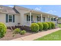 Charming front porch with vintage decorations and green shutters, complemented by lush landscaping at 4916 Ritchie Rd, Lincolnton, NC 28092
