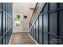Welcoming entryway with hardwood floors, coat hooks, and blue accent wall with view to the front door at 5014 Forest Hills Pl, Fort Mill, SC 29707