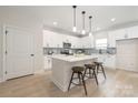 Modern kitchen features white cabinets, a center island with seating, and stainless steel appliances at 515 Dixie Dr, Mooresville, NC 28115