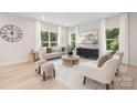 Elegant living room with neutral tones, large windows, stylish furnishings, and wood flooring at 515 Dixie Dr, Mooresville, NC 28115
