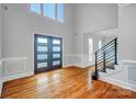 Bright foyer featuring dark double doors, hardwood floors, and a modern staircase with metal banisters at 520 Beacon Knoll Ln, Fort Mill, SC 29708