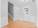 Bright entryway with staircase, white trim, and light hardwood floors at 8309 Shinkansen Dr, Charlotte, NC 28213