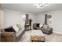 Inviting living room features modern gray sofas, a patterned ottoman, and bright natural light at 92 Saint Charles Ne Ave, Concord, NC 28025