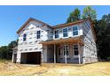 New two-story home with an attached two-car garage and covered front porch framed by large windows at 9945 Cask Way, Huntersville, NC 28078