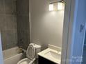 Modern bathroom featuring gray tiled shower, contemporary vanity, and updated fixtures at 1004 Johnson St, Charlotte, NC 28206