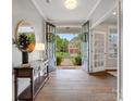 The foyer features hardwood floors and black french doors opening to the front porch, with decorative console table at 1014 Harrogate Ln, Matthews, NC 28104
