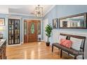 Inviting foyer with a wood door, hardwood floors, decorative lighting and a stylish bench at 10545 Mount Holly Huntersville Rd, Huntersville, NC 28078