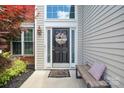 A welcoming front entrance adorned with a decorative wreath and stylish bench at 16337 Greybriar Forest Ln, Charlotte, NC 28278