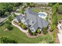 An aerial view of the house featuring a backyard oasis with a pool, spa, and lush landscaping at 18207 Shearer Rd, Davidson, NC 28036