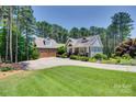 A charming two-story home with a manicured lawn, lush landscaping, and a spacious driveway leading to a two-car garage at 18311 Rosapenny Rd, Charlotte, NC 28278