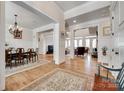 An open-concept living space with hardwood floors, elegant dining set, and fireplace for a warm and inviting ambiance at 18311 Rosapenny Rd, Charlotte, NC 28278