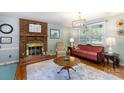 Cozy living room features a brick fireplace, hardwood floors and comfortable seating at 205 Wrentree Ln, Gastonia, NC 28056
