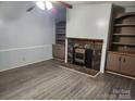 Cozy living room with stone fireplace, built-in shelving, and durable wood-look laminate flooring at 269 Saddle Rd, Lancaster, SC 29720