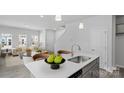 Open concept kitchen with stainless sink, light countertops and view of bright open living area at 2906 Sloan Dr, Charlotte, NC 28208