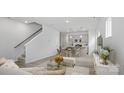 Bright, open-concept living space featuring modern décor, wood-look flooring, and a staircase at 2914 Sloan Dr, Charlotte, NC 28208