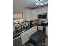 Modern kitchen featuring white cabinetry, black countertops, and stainless steel appliances at 2939 Lasalle St, Charlotte, NC 28216