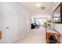 Bright hallway leading to a living area with plush carpeting, creating a seamless transition between spaces at 3050 Des Prez Ave, Fort Mill, SC 29707