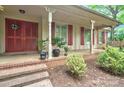 Inviting covered front porch with brick steps, a vibrant red door, and classic columns enhancing the entrance at 3430 Rea Rd, Charlotte, NC 28226