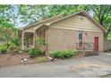 Side view of a brick home featuring a cozy outdoor area with lush landscaping and a private entrance at 3430 Rea Rd, Charlotte, NC 28226