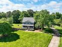 An aerial shot showcases a well-manicured lawn and mature trees surrounding the lovely two-story house at 4628 Dovefield Ln, Kannapolis, NC 28081