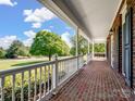 Relaxing brick porch features a swing and a view of the yard at 4628 Dovefield Ln, Kannapolis, NC 28081