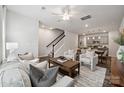 Inviting living room with modern decor, ceiling fan, staircase, and seamless flow into the dining and kitchen areas at 4738 Lakeview N Rd # 16, Charlotte, NC 28216