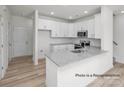 Bright, open kitchen features granite countertops, stainless appliances, and wood-look floors at 5203 Shasta St # 5203, Gastonia, NC 28052