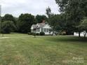 Charming home with meticulously maintained lawn, complemented by lush greenery and mature trees in a serene setting at 609 E Church St, China Grove, NC 28023